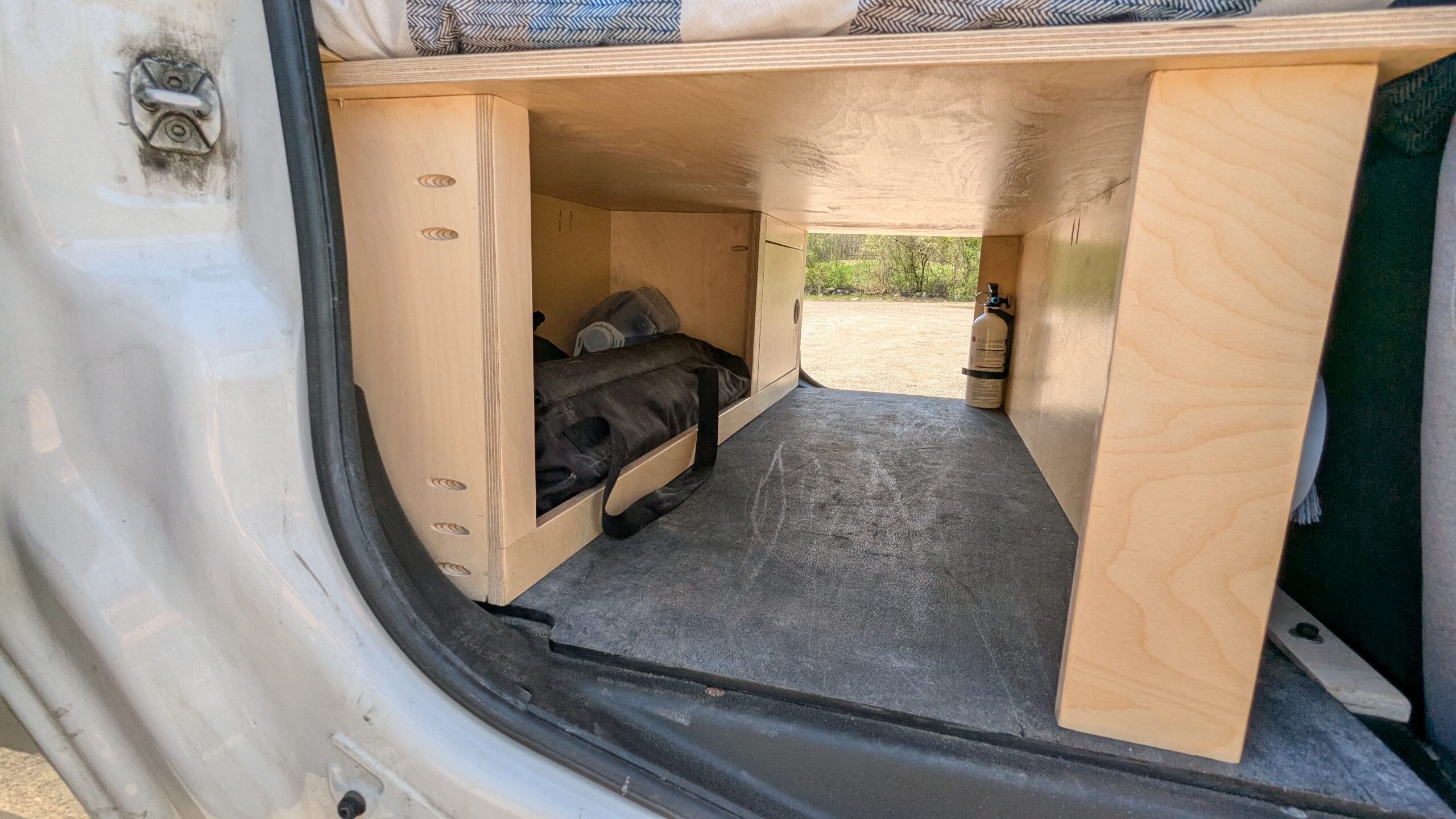 Espace de rangement pleine longueur sous le lit avec deux chaises et une table pliantes